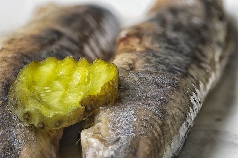 Slice of pickle on salted herring