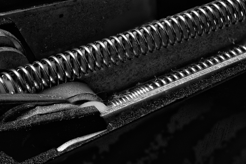 The inside of a dusty old stapler