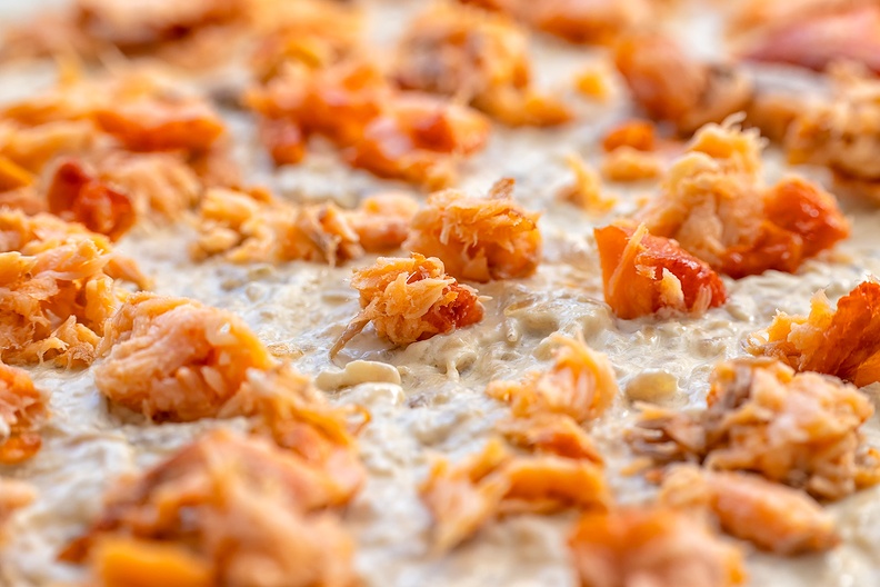Making flammkuchen with salmon and onions