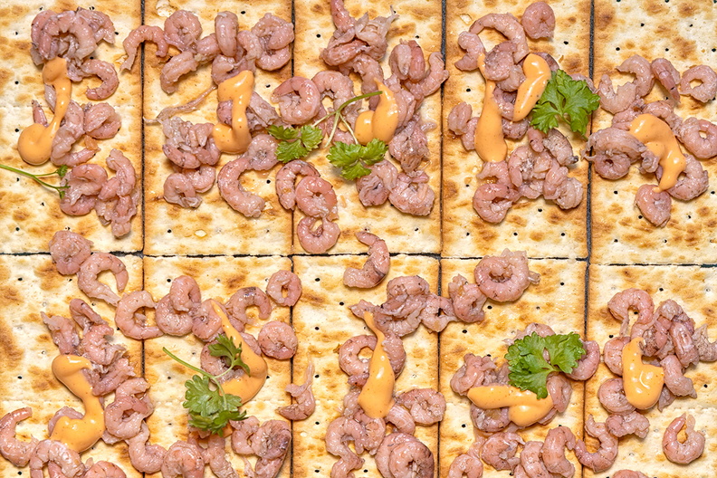 An afternoon snack. Crackers with shrimp and cocktail sauce.