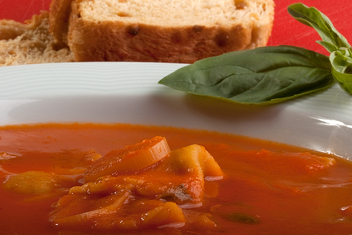 Tomato soup with ravioli and basil.
